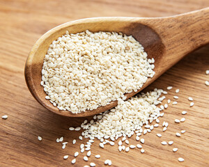 Sesame seeds in a spoon on a rustic table