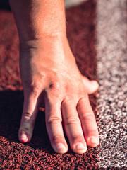 Starting line with outstretched fingers. Stadium racetrack