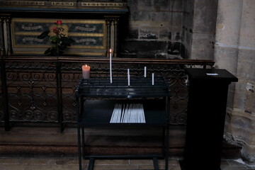Cierges et bougies sur un présentoir dans une église.