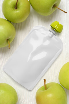 White empty plastic pouche for baby food, mock-up on wood table. 3d rendering.