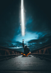 Man on the bridge sending magical power to heaven at night