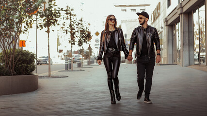 sexy couple walks in the city in leather suits