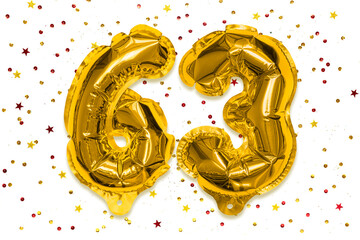 The number of the balloon made of golden foil, the number sixty three on a white background with...