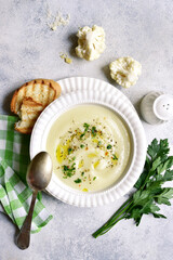 Cauliflower creamy soup with potatoes and cheese. Top view with copy space.