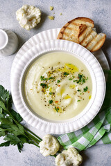 Cauliflower creamy soup with potatoes and cheese. Top view with copy space.