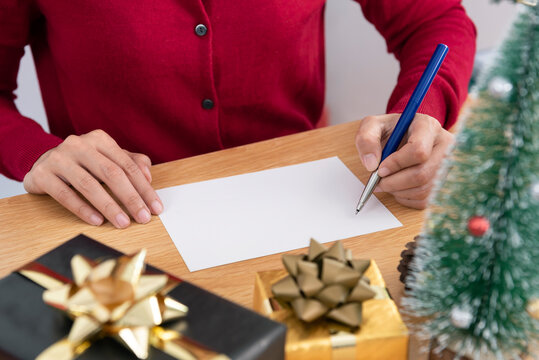 Hand writing mockup greeting card for Merry Christmas and Happy new year with Christmas decoration on wood table.