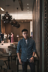 Asian young handsome man standing in coffee shop and smiling. Chinese guy, millennials life, lifestyle in the big city, Modern Asia, coffee break