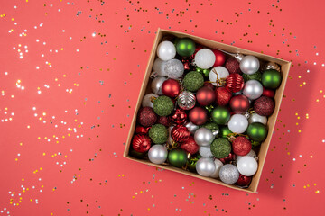 Golden stars and Christmas balls in a box on a red background. Beautiful new year card