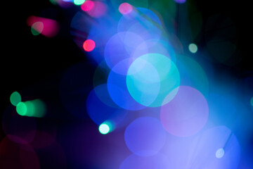 Blue, red and green bokeh on a black. Abstract festive background.