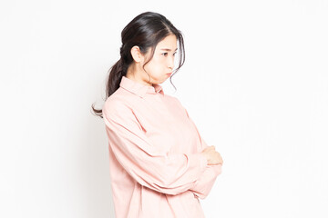 白背景の前で怒っているポーズをする女性