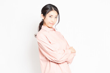 白背景の前で怒っているポーズをする女性