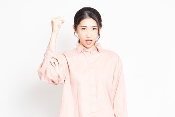 白背景の前で怒っているポーズをする女性