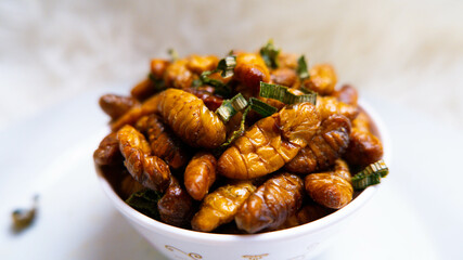 Close-up of fried bamboo worms for sale in the market. , Close-up Oily taste and salty silkworms. ,...