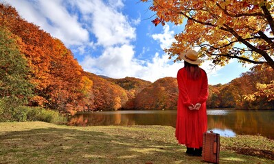 旅行・湖畔の紅葉を楽しむ女性