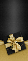 Black Friday gift package wrapped with golden ribbon bow  isolated on black background, template...