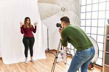 Young woman at photography studio relax and smiling with eyes closed doing meditation gesture with fingers. yoga concept.