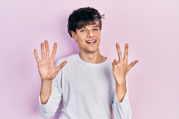 Handsome hipster young man wearing casual white shirt showing and pointing up with fingers number eight while smiling confident and happy.