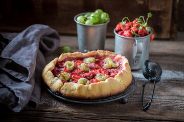 Tasty tart with gooseberries and strawberries Berries tart with sugar.