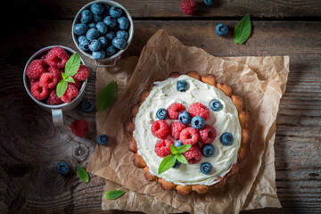 Creamy tart with blueberries and raspberries. Homemade berries tart.