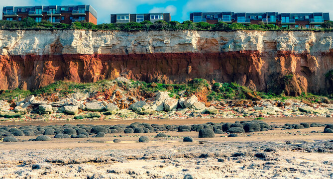 Blocks of flats very close to the top of the stripy cliffs in Hunstanton in Norfolk indicating dangers of coastal erosion in East Anglia, UK