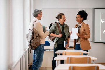 Adult student and their African American professor communicate after class in classroom.