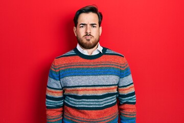 Handsome caucasian man with beard wearing elegant wool winter sweater skeptic and nervous, frowning upset because of problem. negative person.