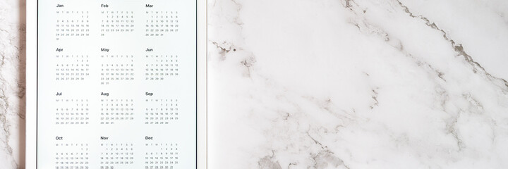 tablet computer with an open app of calendar for unspecified date year without date on a gray marble background. concept business or to do list goals with technology using. top view, flat lay. banner