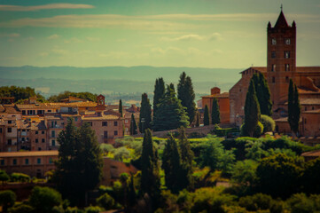 Naklejka premium Montepulciano. Warm elevated image of cypress trees amid the ornate Italian buildings under an evening Tuscan sun.