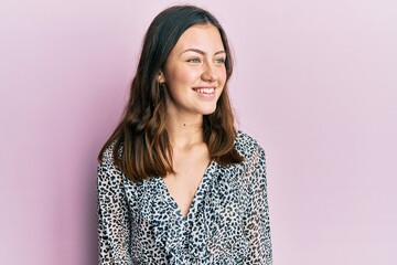 Young brunette woman wearing elegant animal print shirt looking to side, relax profile pose with natural face and confident smile.