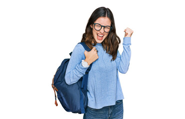 Young beautiful girl wearing student backpack screaming proud, celebrating victory and success very...