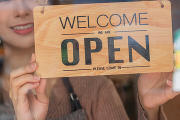 Smiling asian young business owner, employee retail,coffee shop woman,girl turning,setting sign board to open for welcome customer, reopen store after close lockdown quarantine in covid.Label concept.