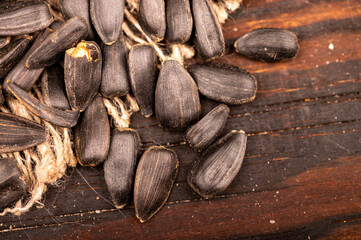 Fried black sunflower seeds scattered on the table, close-up, selective focus.