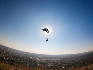 Fototapeta na wymiar Man flying extreme paragliding alone at sunny day, freedom concept. Budapest