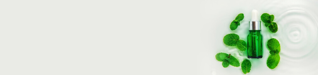 Cosmetics in a bottle in water, skin hydration concept. Selective focus.