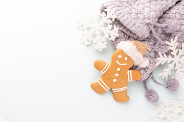 Gingerbread man, cookies and Christmas decor on pastel background.