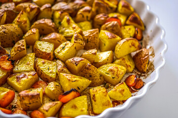 Roasted potatoes in the oven with spices and herbs close-up, food background life style, homemade potatoes recipe authentic, vegan cuisine