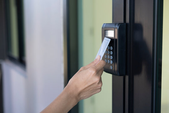 young woman using RFID tag key, fingerprint and access control to open the door in a office building