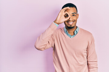 Young african american man wearing elegant clothes smiling happy doing ok sign with hand on eye looking through fingers
