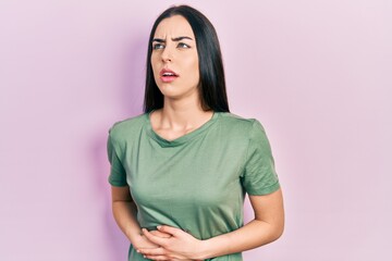 Obraz premium Beautiful woman with blue eyes wearing casual t shirt with hand on stomach because nausea, painful disease feeling unwell. ache concept.