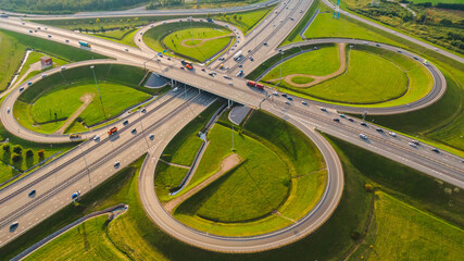 Aerial view of an automobile road junction intersection with bridges and trucks and cars on a sunny...