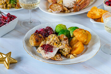 Traditional Christmas dinner with roasted turkey, apricot and pistachio stuffing, roast potatoes and cranberry sauce