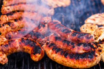 Grilling sausages and pork chops on barbecue grill. BBQ in the garden