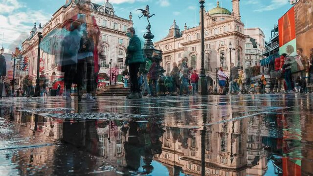 Timelapse of the crowded Piccadilly Circus in London during daytime. The Circus is known for its video display and neon signs mounted on the corner building.