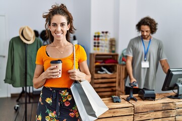 Man and woman customer holding shopping bags drinking coffee at clothing store