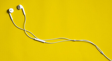 earphones for smartphone on yellow background