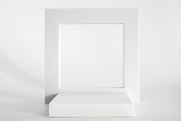 White podium on the white background, simple geometric forms. Podium for product, cosmetic presentation. Creative mock up. Pedestal or platform for beauty products.