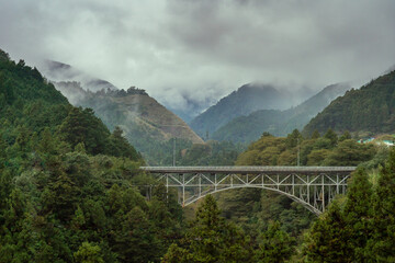 Obraz premium Misty mountain forest and Bridge landscape in the cold morning. fantasy forest Okutama japan