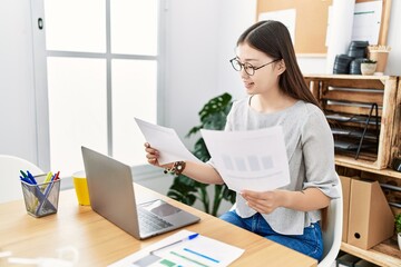 Young asian woman working looking at documents at the office
