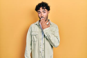 Young hispanic man wearing casual clothes bored yawning tired covering mouth with hand. restless and sleepiness.