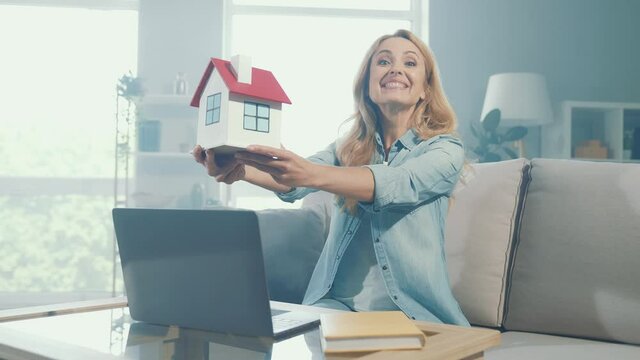Cheerful nice glad lady enjoy relocation proposition hold paper house